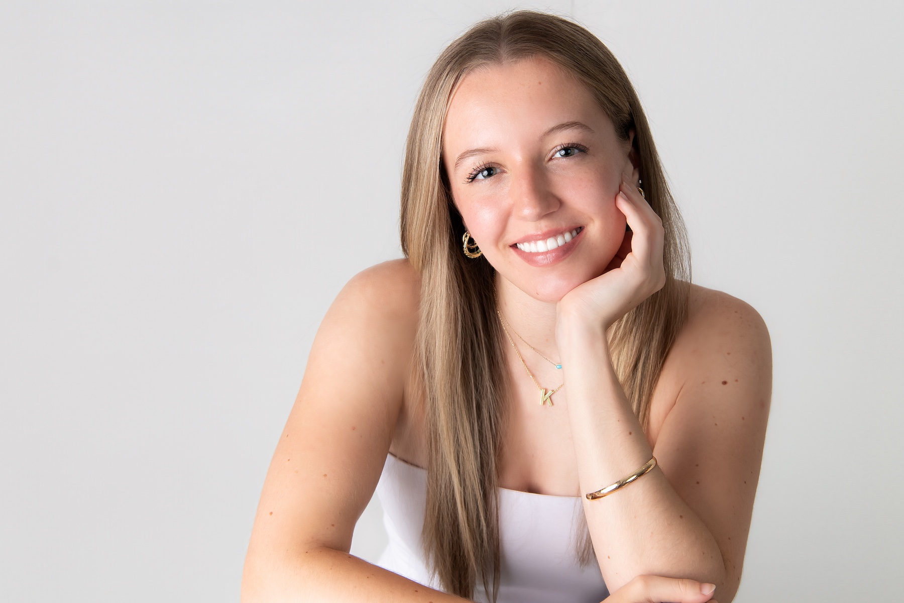 Teenage girl dressed in a white dress photographed in a clean, modern studio portrait in a Main Line studio.