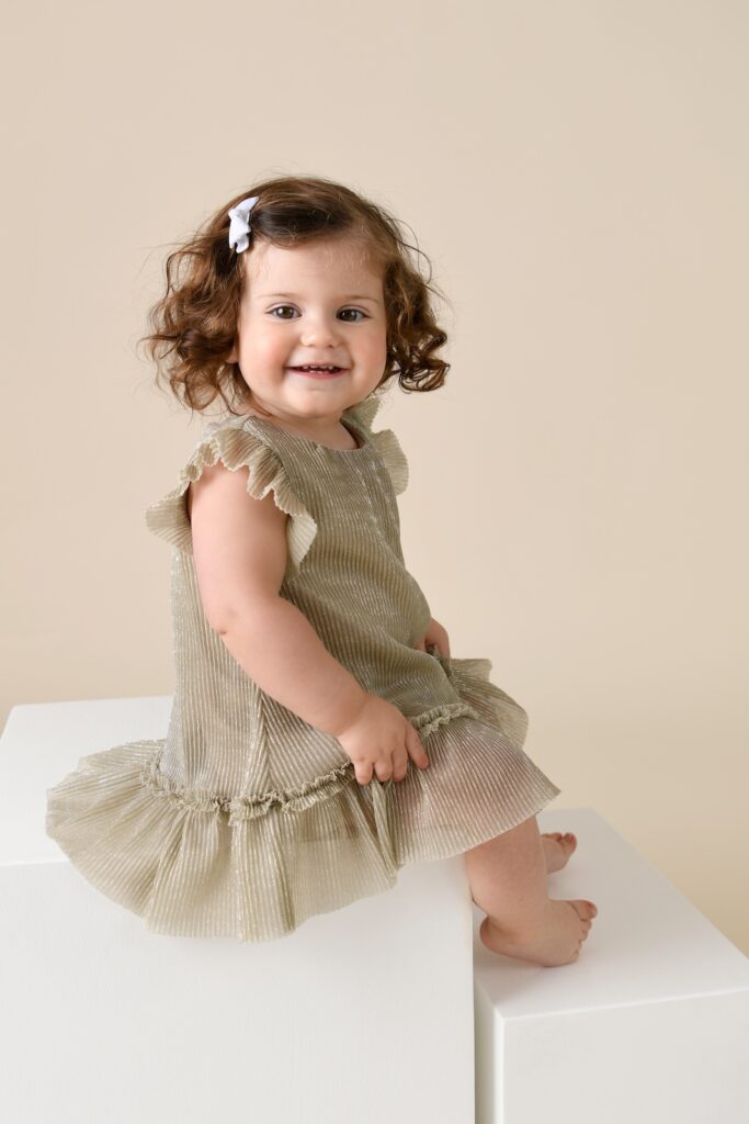 Toddler girl sitting on white posing blocks during a child portrait photography session in Glen Mills, Pennsylvania.