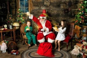 Santa and two children discover glowing Christmas boxes during a Magic of Santa session.