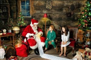 Santa shows two children his long Christmas list during a Magic of Santa photography session.