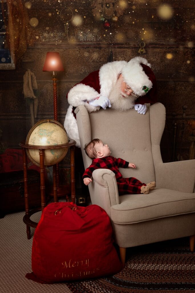 Baby looking up at Santa during a magical Christmas portrait session at a Glen Mills studio.