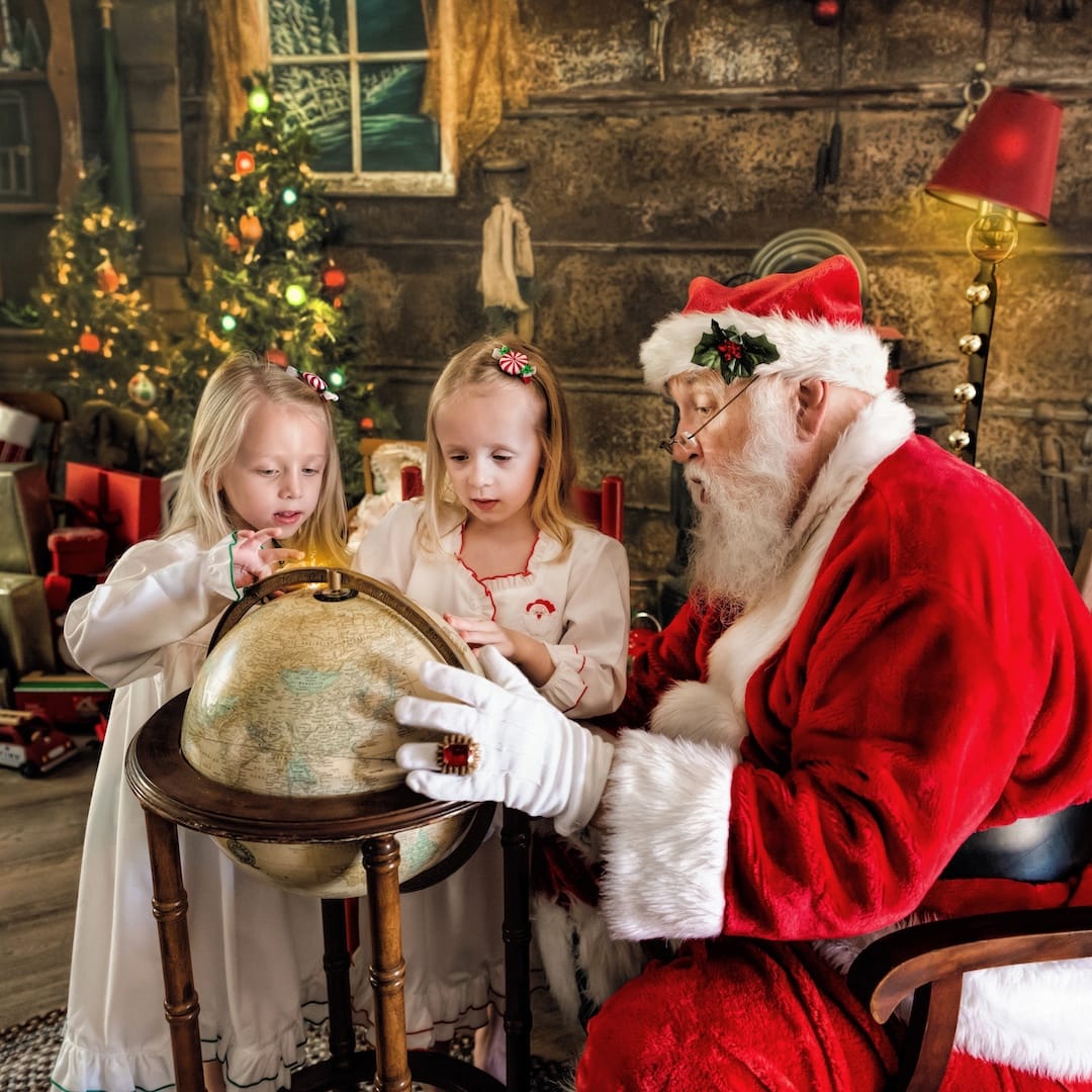 Children explore a globe with Santa during an interactive Santa photography experience near Media, PA.