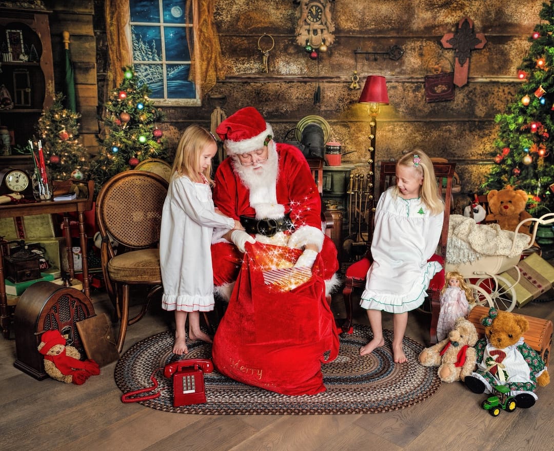 Santa reveals a glowing Christmas gift to two children during a magical Santa experience near Radnor, PA.